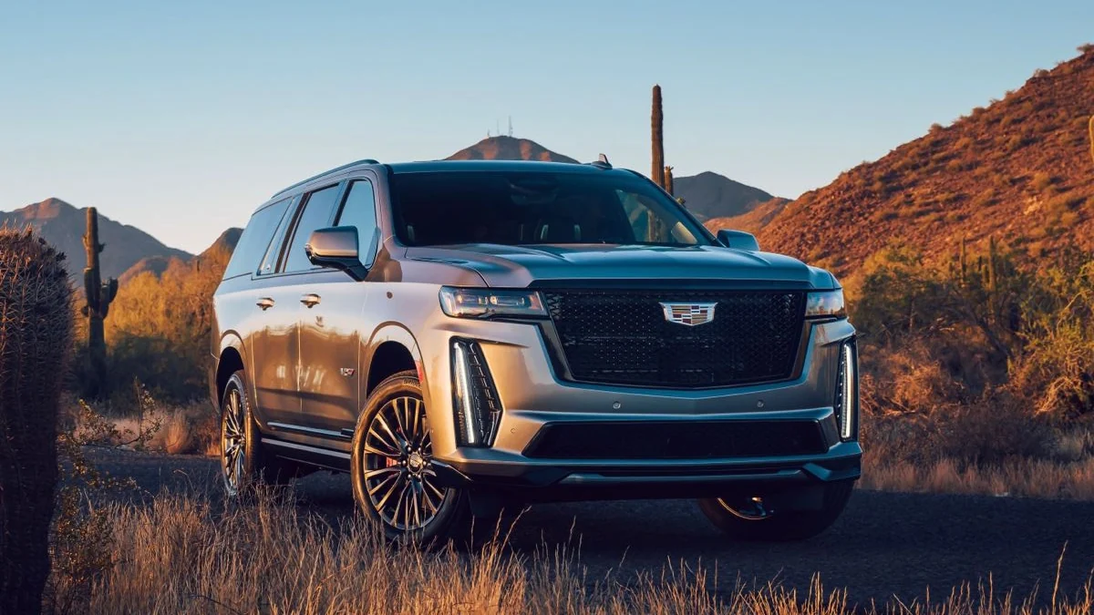 SUV de lujo plateada en un camino del desierto al atardecer